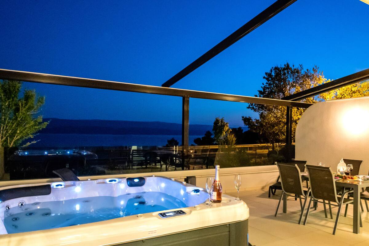 A hot tub with a table and chairs, overlooking a scenic view.