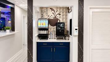 A coffee station with a coffee machine, a milk frother, and a coffee dispenser.