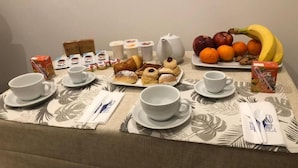 A breakfast buffet with various pastries, fruits, and beverages on a table. - B&B Bethel Napoli (Naples)