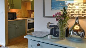 Une cuisine avec des meubles de rangement en bois, un four à micro-ondes et une cuisinière.
