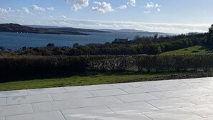 A paved outdoor area with a view of a body of water and distant hills.