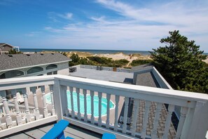 A pool with a clear view of the beach and ocean in the background. - OCEANFRONT, 17 BRs, Ocean Views, Priv Pool, Rec Rm, Theatr Rm! 4x1487, The Dream (Corolla)
