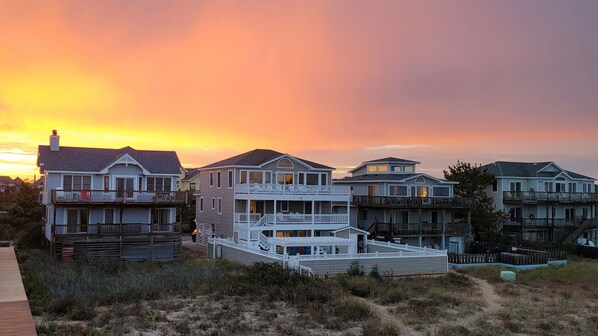 A beachfront property with multiple houses featuring balconies and a wooden deck.