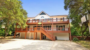 A two-story building with a balcony and a staircase leading to the upper level. - Oceanside, Private Pool, Golf Cart, Bar, Hot Tub, Rec Rm, SS4, Sunning Your Bunns (Southern Shores)
