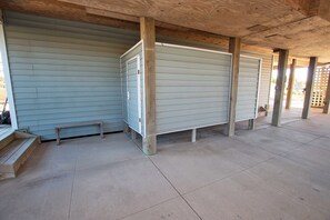 A covered outdoor area with a concrete floor, wooden benches, and metal lockers. - OCEANFRONT, Ocean Views, Private Beach Walkway! NH1, Blackbeard's JEM (Nags Head)