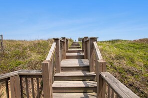 A wooden staircase leading to a higher elevation, surrounded by grassy terrain.