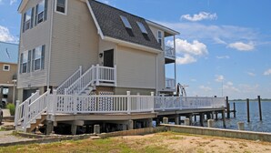 A two-story house with a balcony and a dock extending into the water. - Unique & spacious house with boat docks in Tuckerton beach, NJ (Tuckerton)