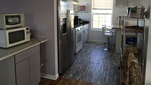 A compact kitchen with a refrigerator, microwave, and stove. - Unique & spacious house with boat docks in Tuckerton beach, NJ (Tuckerton)