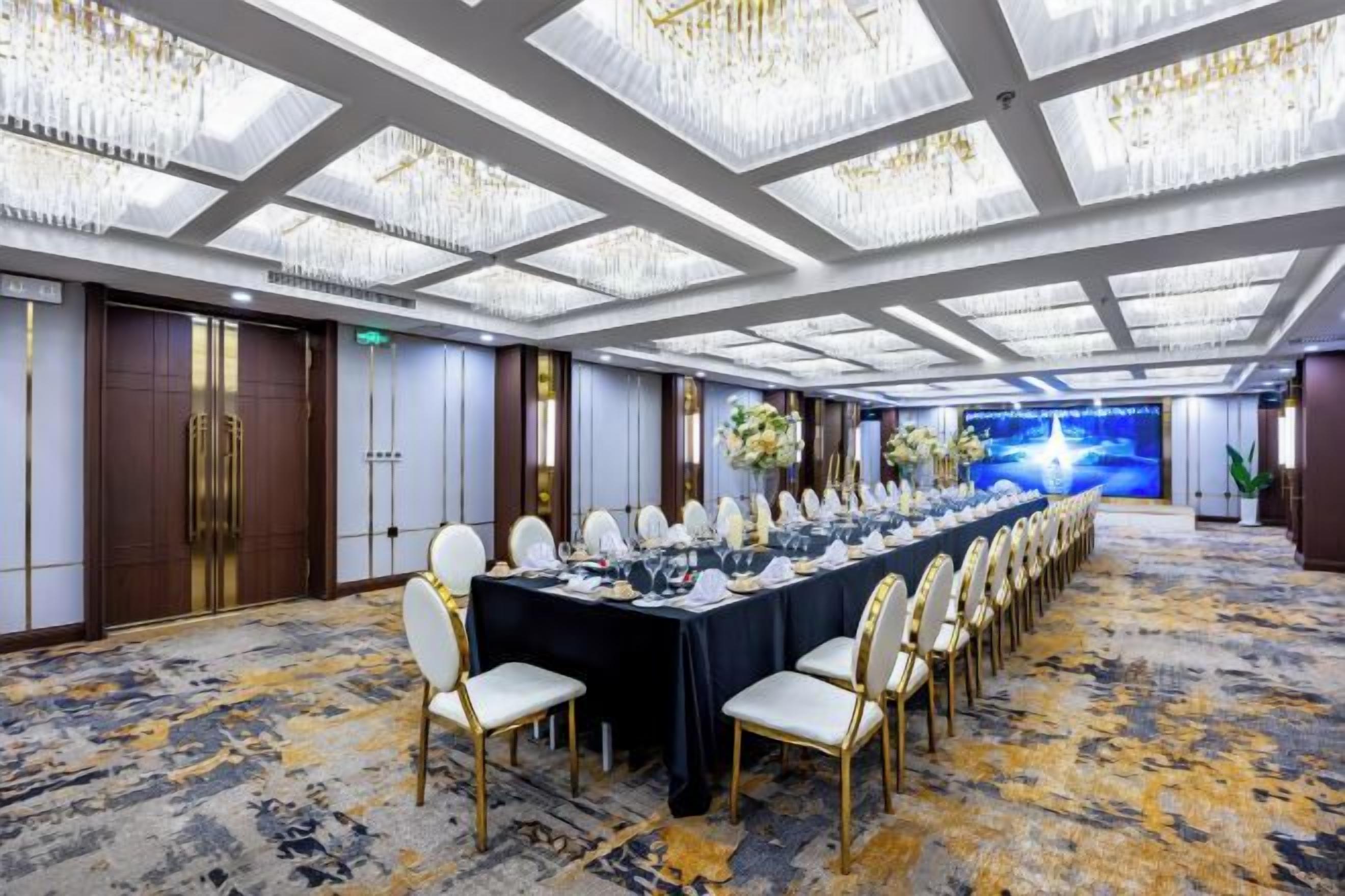 A conference room with a long table, chairs, and a chandelier.