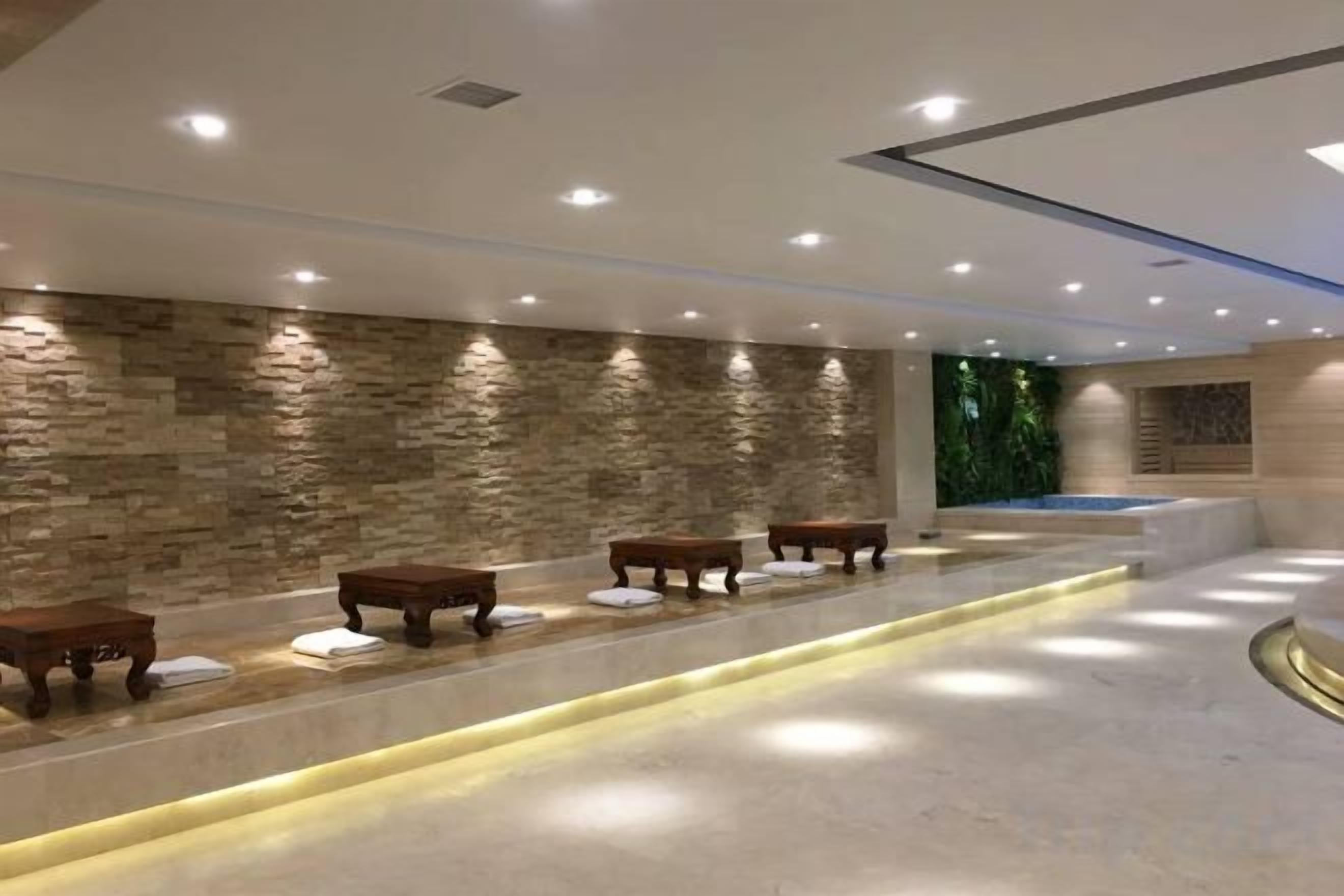 A spa area with stone walls, benches, and a reception desk.