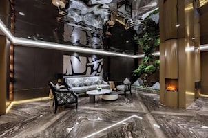 Um interior moderno com piso de mármore, um conjunto de sofás, uma mesa de centro e uma lareira.