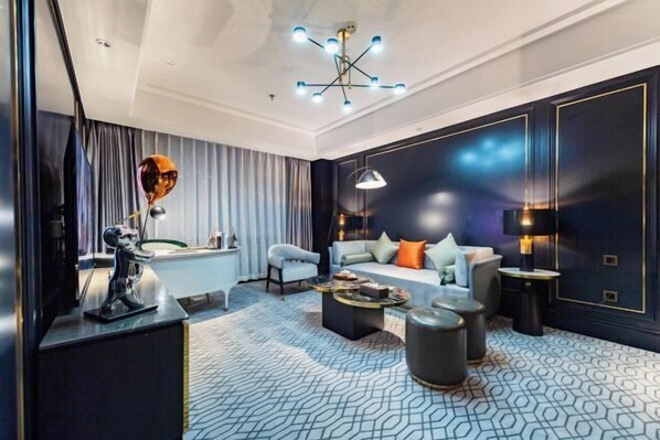 Uma sala de estar moderna com mesa de bilhar, um conjunto de sofás e um candelabro.