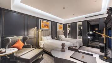 A modern hotel room with a sofa, two beds, a desk, and a mirror.