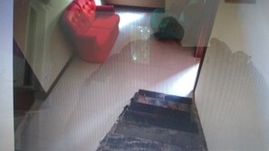 Stairs lead to an upper floor with a window and a chair.