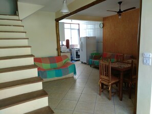 Relax in this inviting living area with a dining table, comfortable sofa, and fully equipped kitchen.