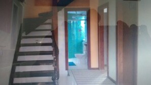 Stairs lead to a room with a window and a blue wall.