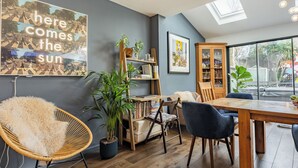 A modern dining area with a wooden table, chairs, and a bookshelf. - 5 bedroom accommodation in Hove (Hove)