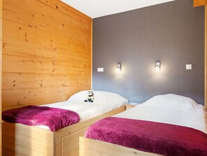 A room with two wooden bunk beds, each with a white mattress and a pink blanket. There are two wall-mounted light fixtures on the gray wall. - Beautiful apartment for 6 people with WIFI, TV and terrace (Châtel)