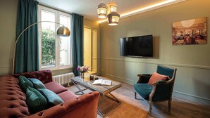 Un salon comprenant un canapé, un fauteuil, une table basse et un téléviseur.