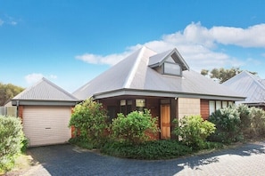 A modern house with a sloped roof, a garage, and a well-maintained garden. - Cowrie Chalet - close to the river and town - Cowrie Chalet - Close to the river (Augusta)