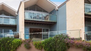 A modern building with a flat roof, large windows, and a balcony. - Seine Bay Apartment (1 bedroom) modern accommodation in the townsite - Seine Bay Apartment (1 bedroom) (Augusta)