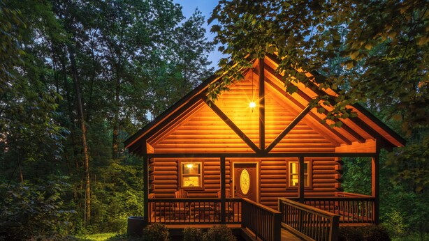 A log cabin with a porch, a staircase, and a window. - Hot Tub, Fire Pit, Large Decks & Blackstone Griddle (Logan)