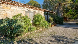 A rustic stone building with a tiled roof, surrounded by lush greenery and a gravel path. - Wonderful private villa for 6 people with A/C, WIFI, TV, terrace and pets allowed (Hyères)
