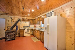 Kitchen features a refrigerator, microwave, stove, sink, and granite countertop.