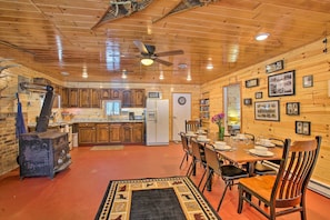 Cozy cabin with a dining area, kitchen, and wooden ceiling.