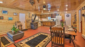 Un interior de madera con comedor, cocina y chimenea.
