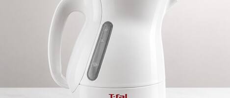 A white T-fal Justine+ electric kettle with a digital display and a handle.