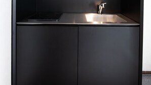 A modern kitchen with a built-in stove, a sink, and a ventilation hood. - Volcano (Kagoshima)