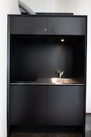 Una cocina moderna con estufa integrada, un lavamanos y una campana extractora.