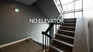 A staircase with a handrail and a light fixture on the wall. - Volcano (Kagoshima)