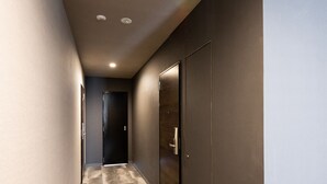 A hallway with a marble floor, dark walls, and a door at the end. - Volcano (Kagoshima)