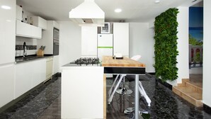 A modern kitchen with white cabinets, a central island, a gas stove, and a built-in oven.