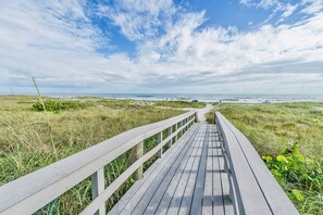 A wooden boardwalk leading to a beach with grassy dunes and a clear blue sky. - Gorgeous Oceanfront 3 Bedroom Penthouse. Stunning Balcony Views ☀️🏖️ (Cocoa Beach)