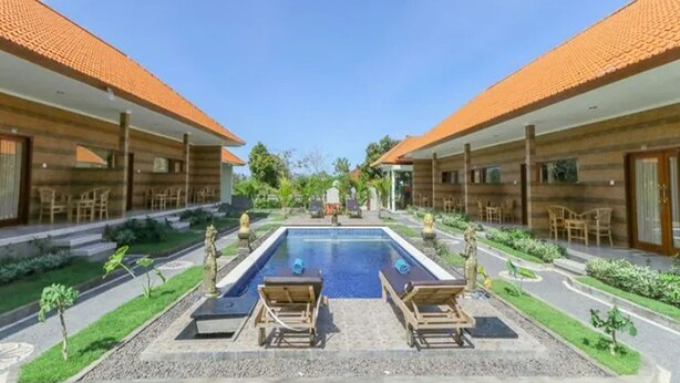 A pool area with lounge chairs and a clear view of the pool. - Manik Homestay Uluwatu by Zuzu (Pecatu)