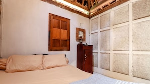 A bedroom with a bed, a wooden wardrobe, a mirror, and a large window with a woven blind. - Segajih Central Stay and Education (Kokap)