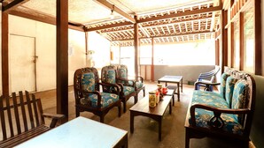 A traditional room with wooden furniture, including a sofa, chairs, and a table.
