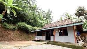 A small, single-story building with a tiled roof and a porch.