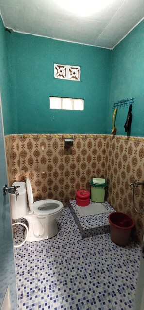 A bathroom with a toilet, bidet, and a small sink area. - Sutrisno Homestay - Hostel (Kokap)