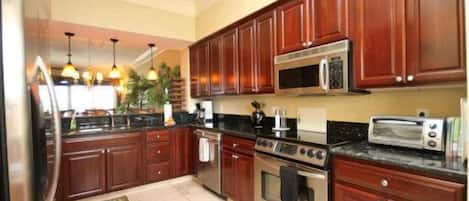 A kitchen with wooden cabinets, a microwave, a stove, and a toaster.