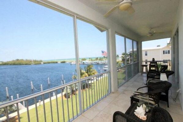 A balcony with a view of a marina and the ocean.