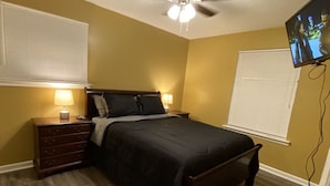 A bedroom with a bed, nightstands, a ceiling fan, and a TV mounted on the wall. - Special offer!!!!!!! (Dothan)