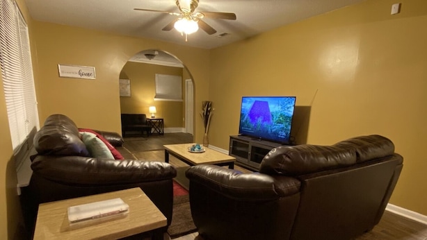 A living room with a brown leather sofa, a wooden coffee table, and a television on a stand. - Special offer!!!!!!! (Dothan)