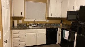 A kitchen with white cabinets, a black microwave, and a dishwasher. - Special offer!!!!!!! (Dothan)