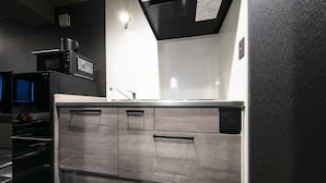 A modern kitchen with stainless steel appliances, a built-in microwave, and a sleek countertop.