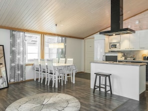 Een moderne keuken met een centraal eiland, witte kasten en een magnetron.