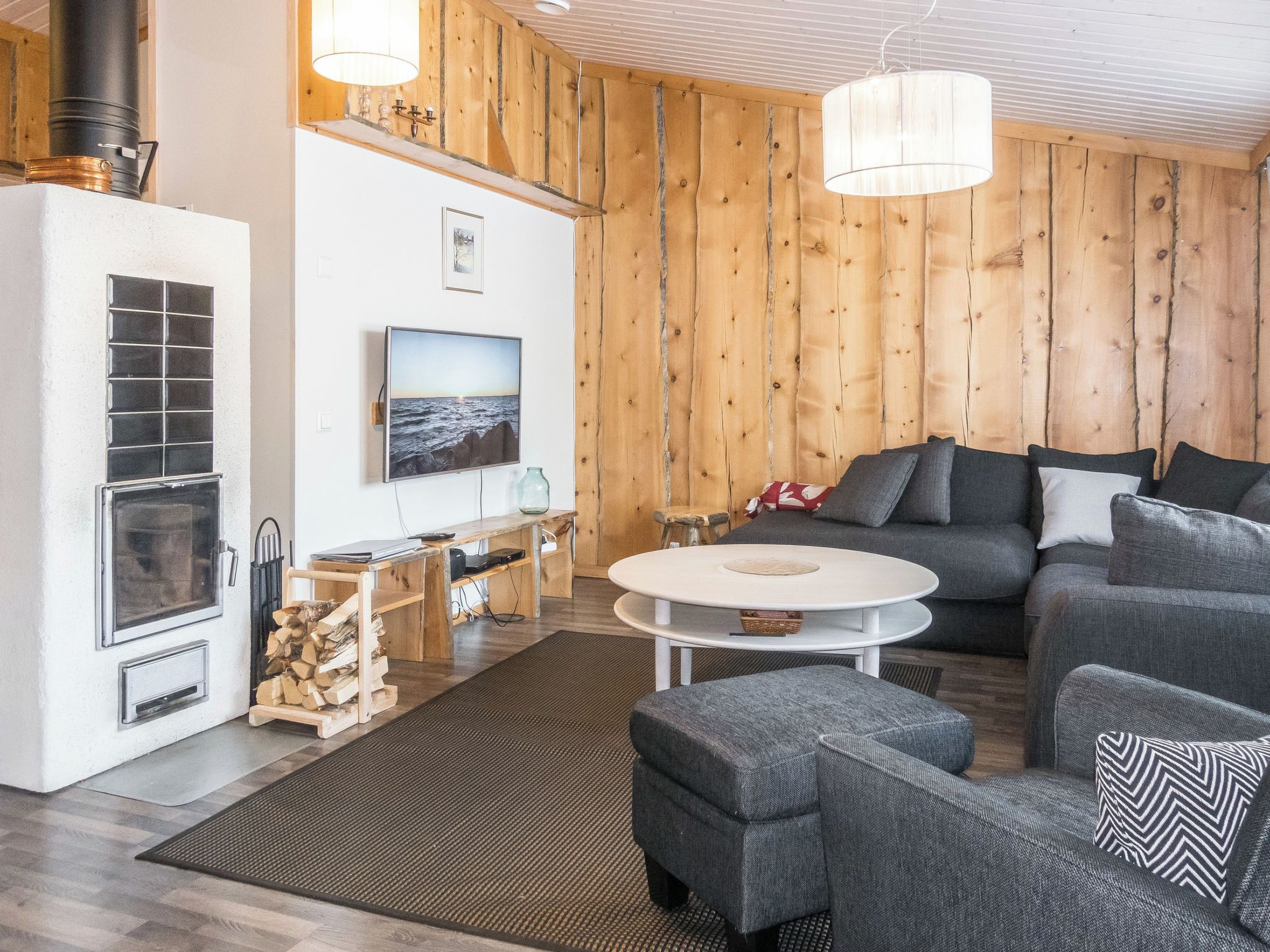 Ein modernes Wohnzimmer mit Kamin, Fernseher, Sofa und Couchtisch.